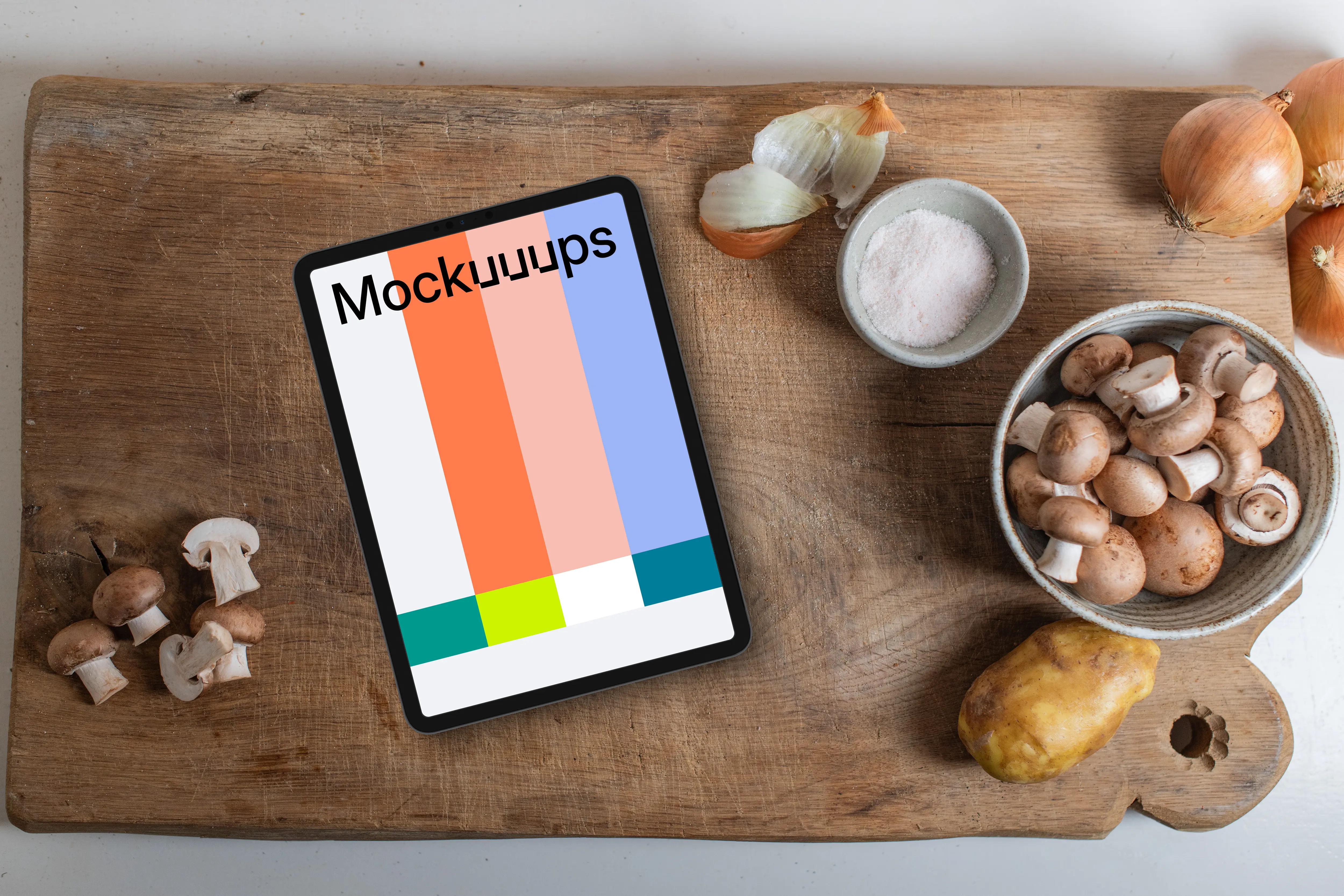 iPad and mushrooms on a wooden chopping board