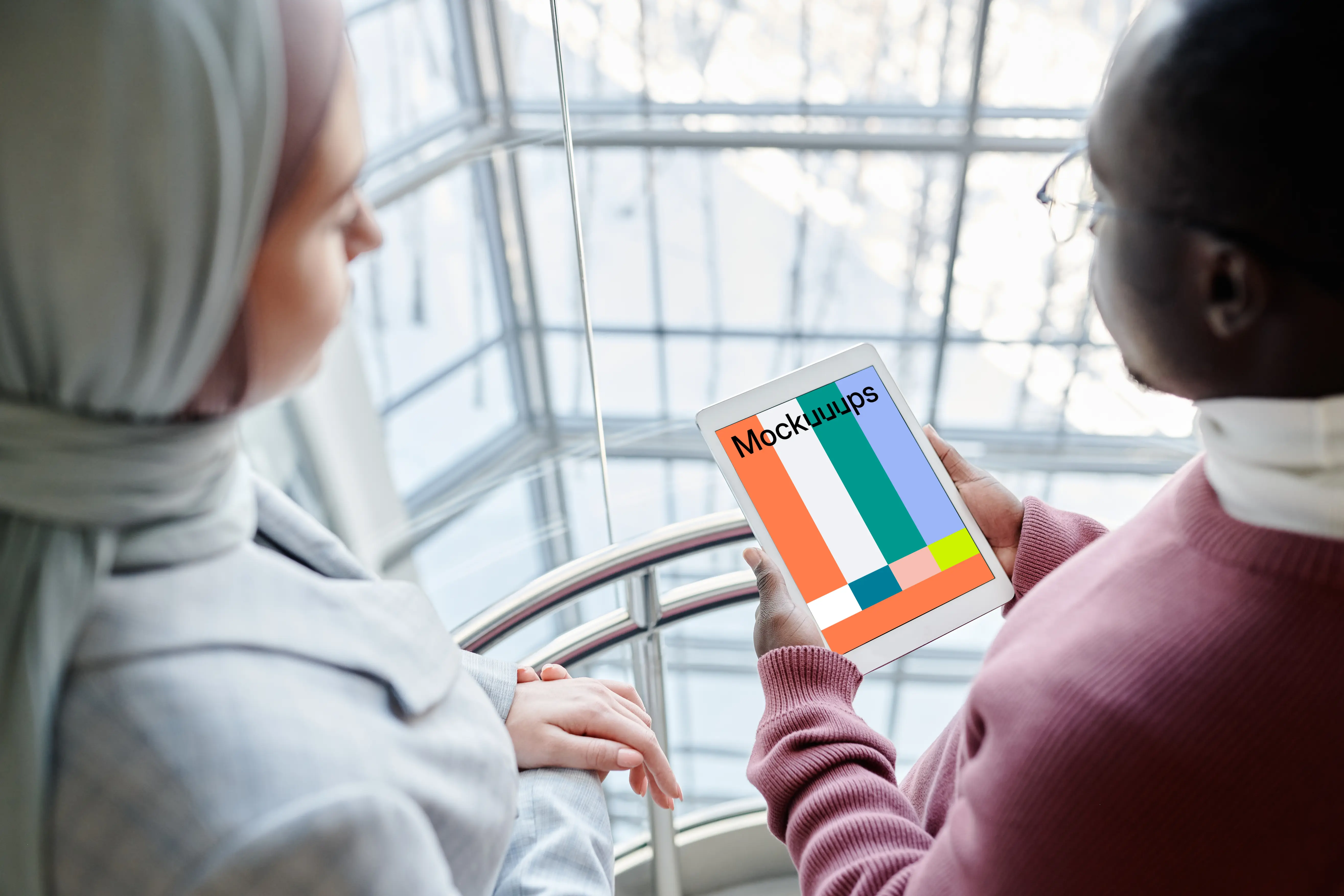 iPad Mini mockup held by a user in with a lady beside him