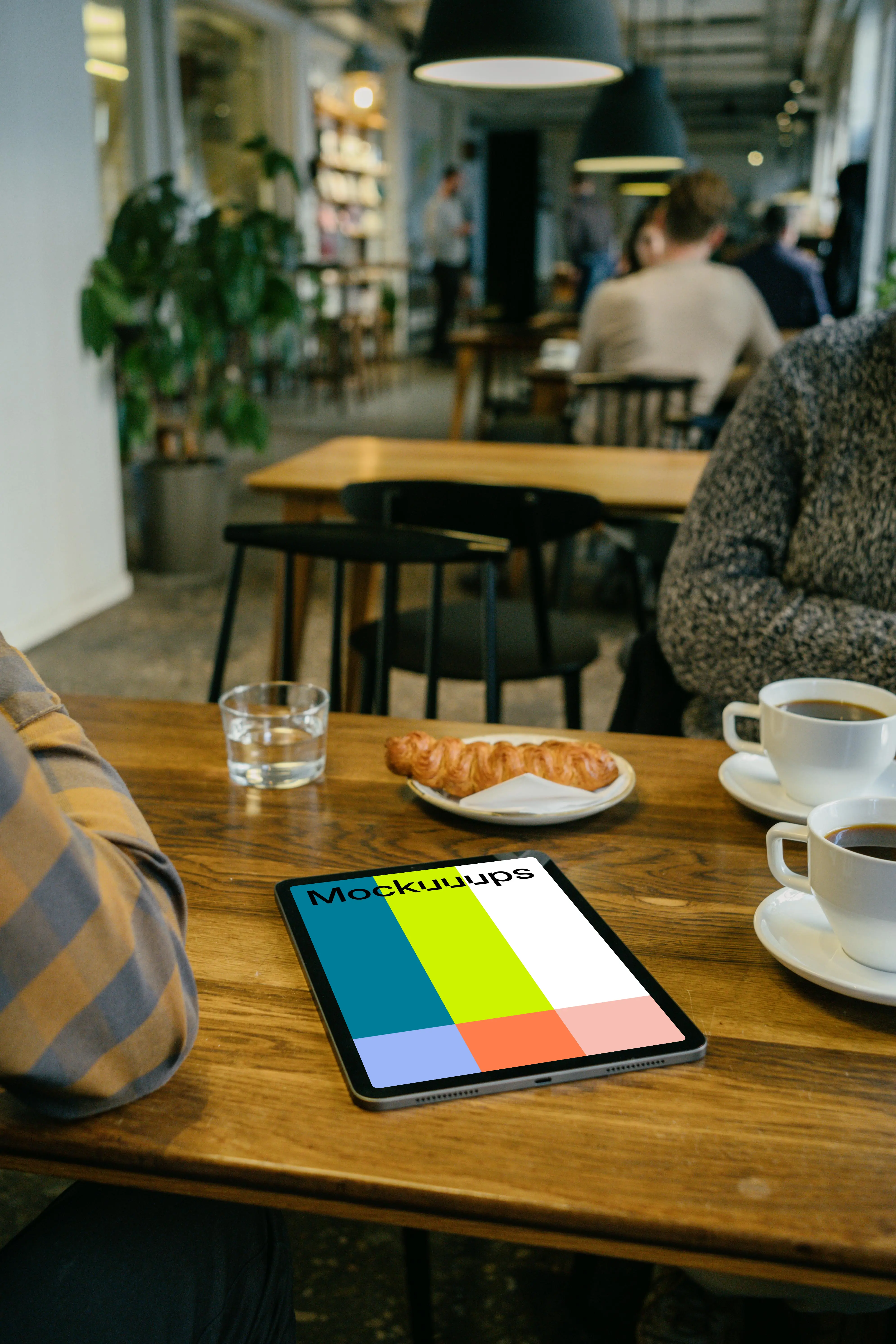 iPad mockup in front of a user beside a croissant