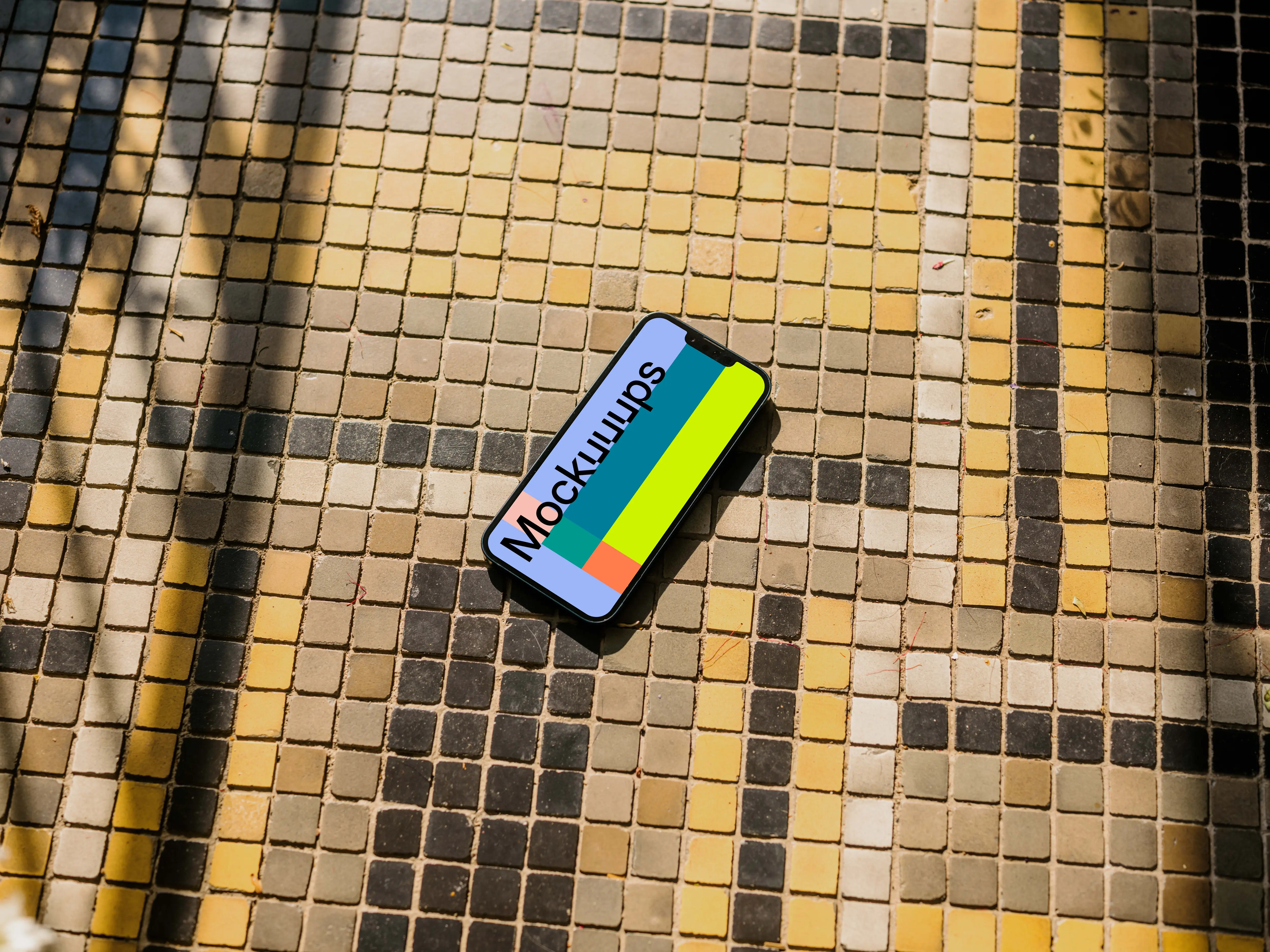 iPhone 13 mockup on a colorful garden paving