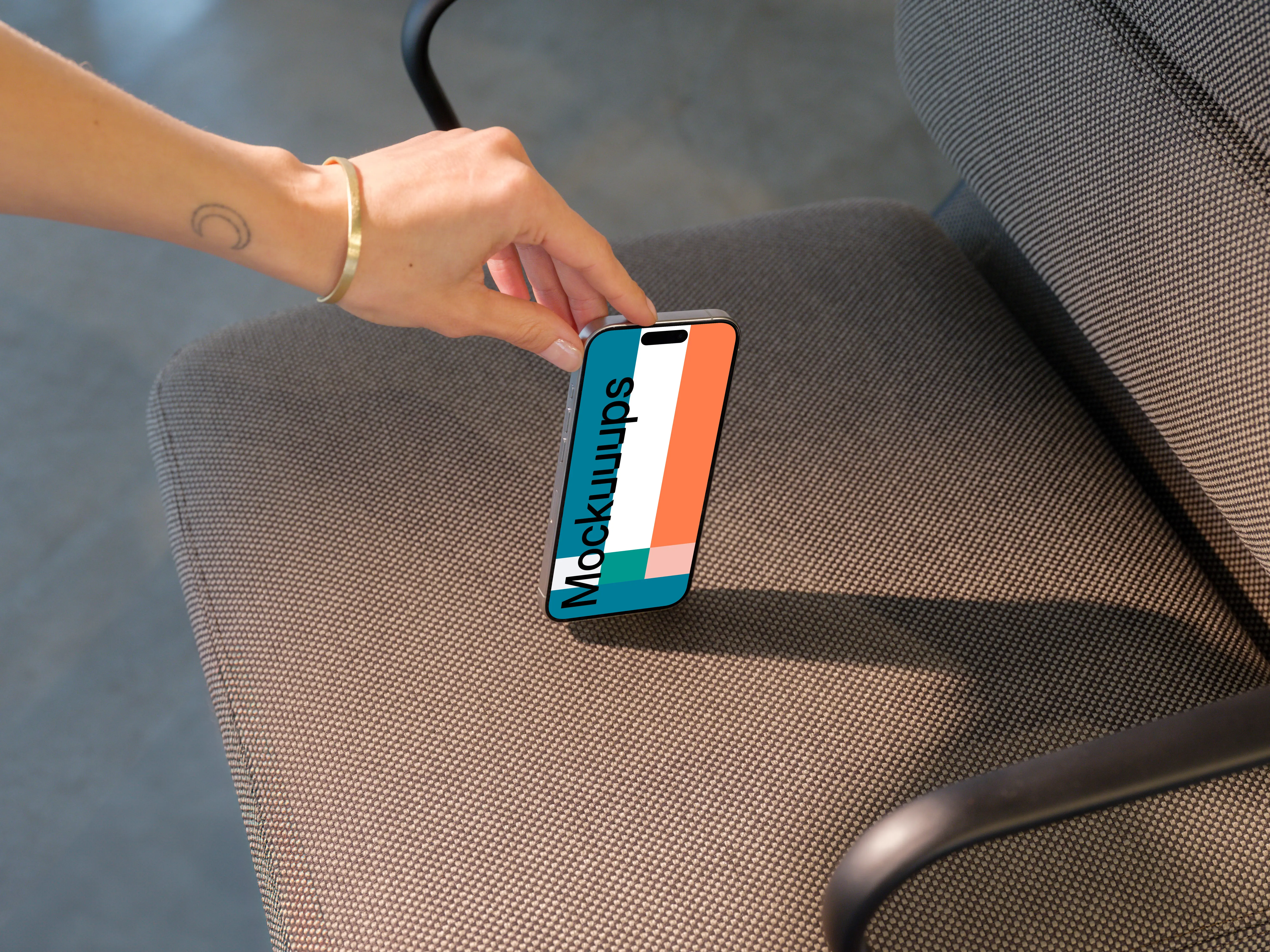 iPhone 15 Pro mockup in a modern office chair