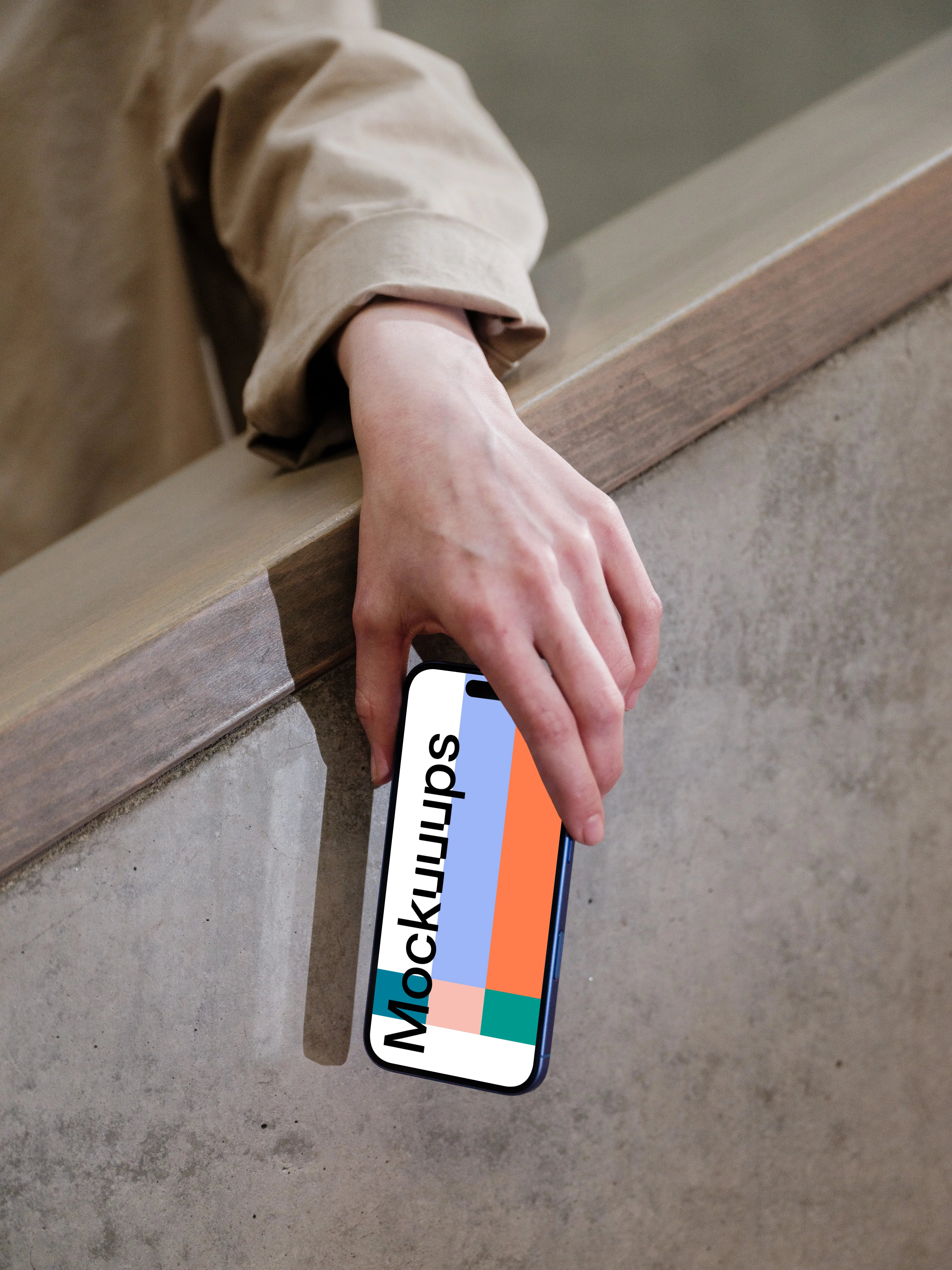 iPhone 16 mockup held by hand against concrete