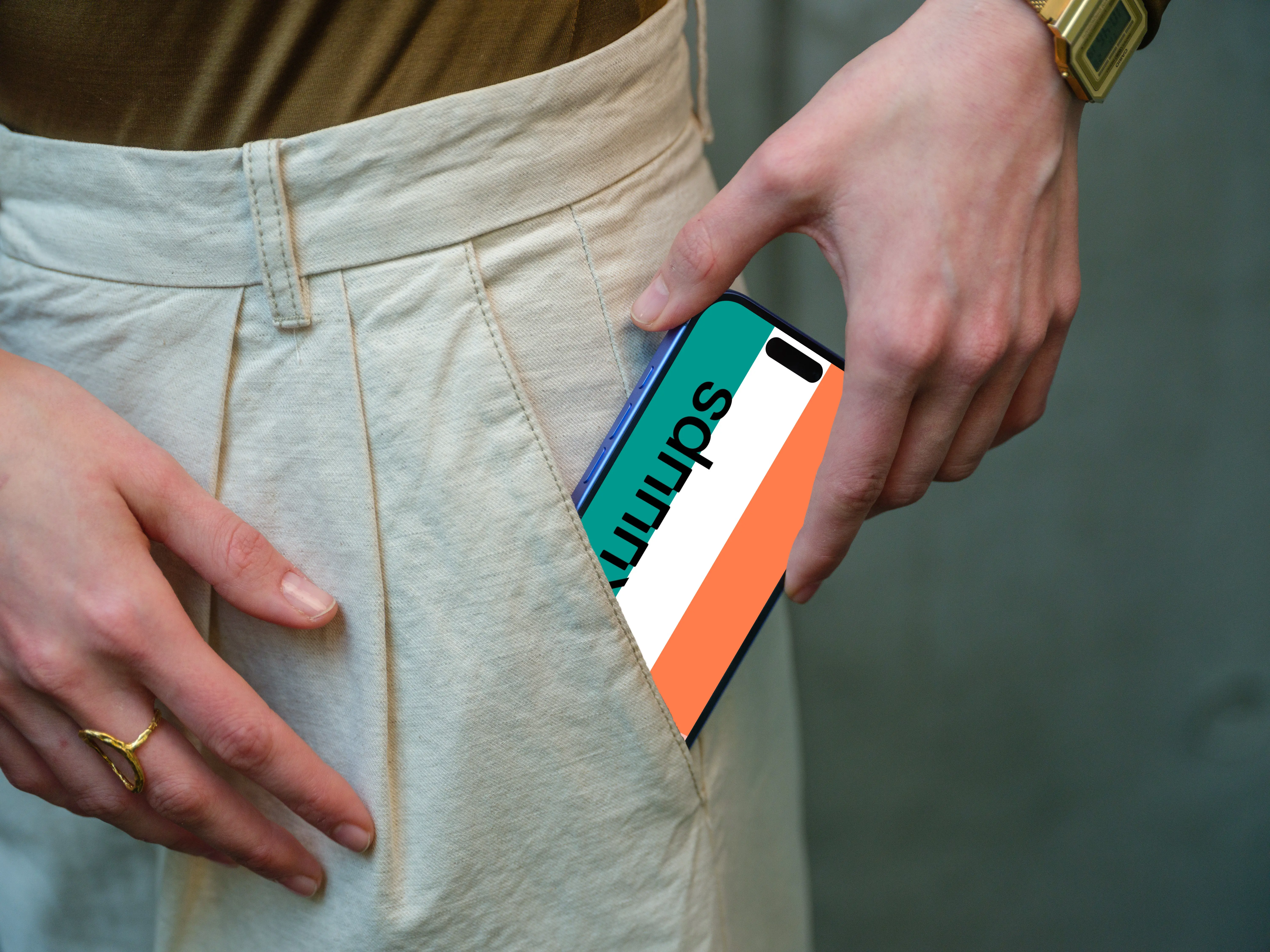 iPhone 16 mockup in hand with casual outfit