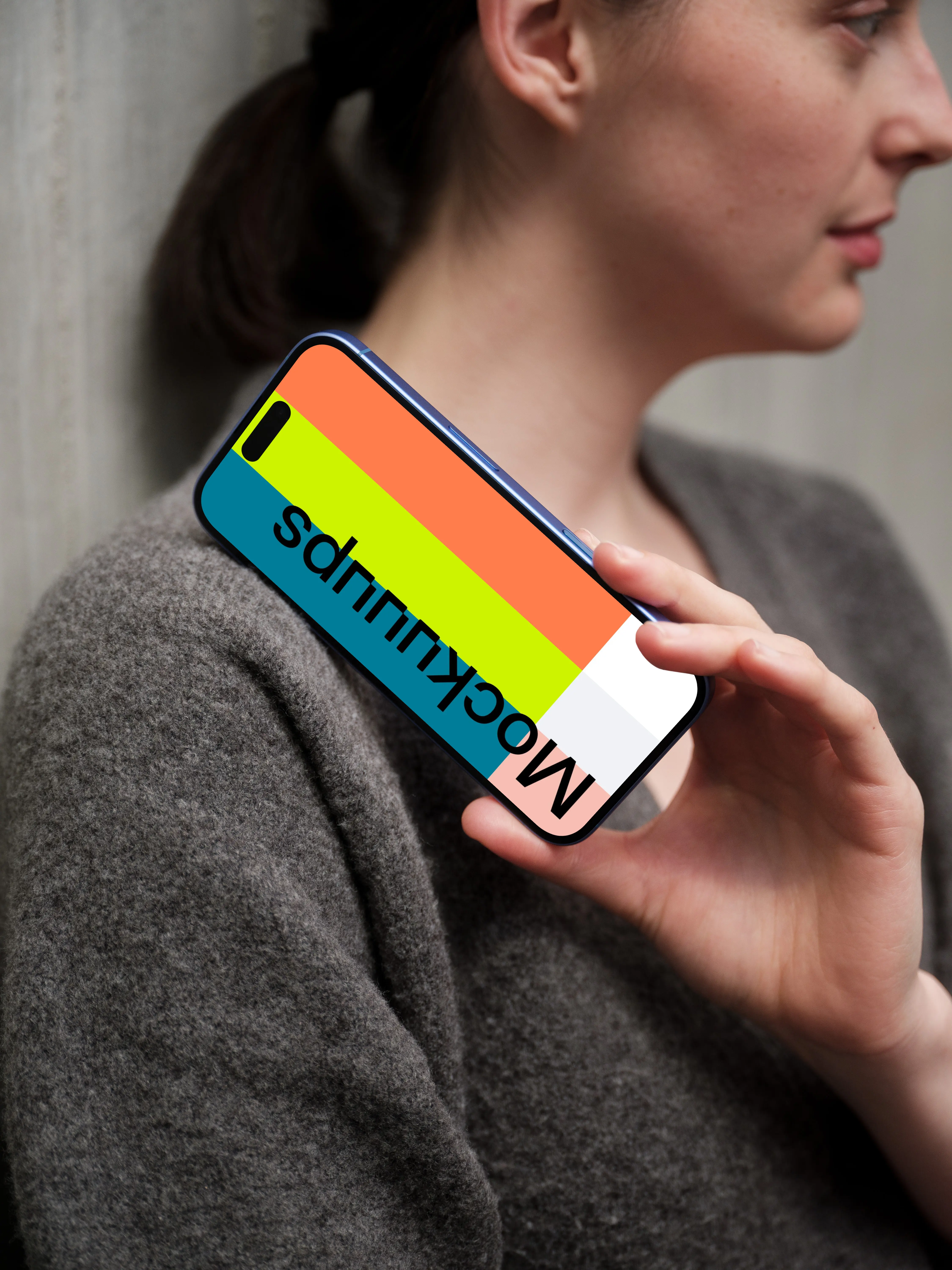 iPhone 16 mockup with hand and concrete wall