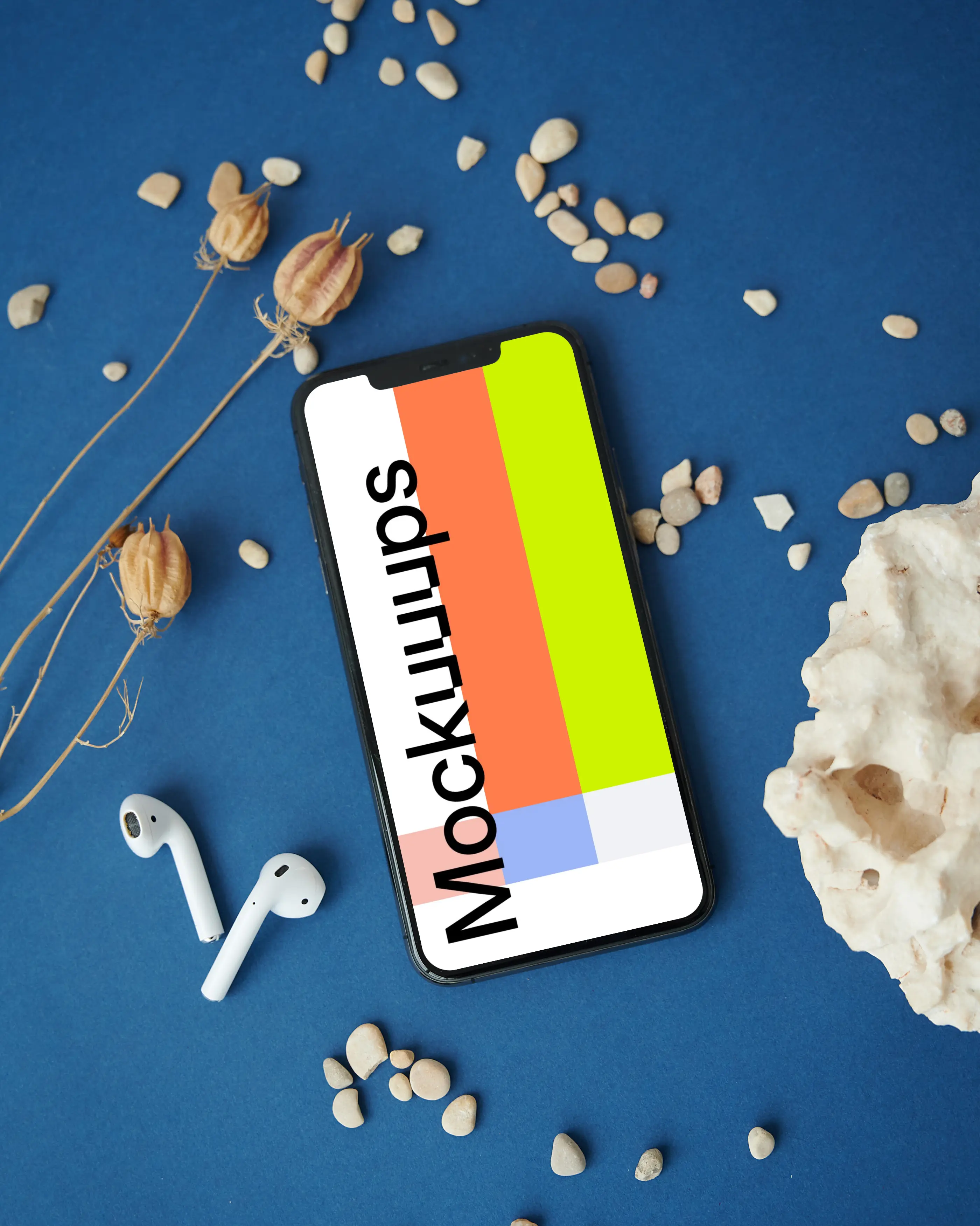 iPhone mockup on a table beside a pair of AirPods