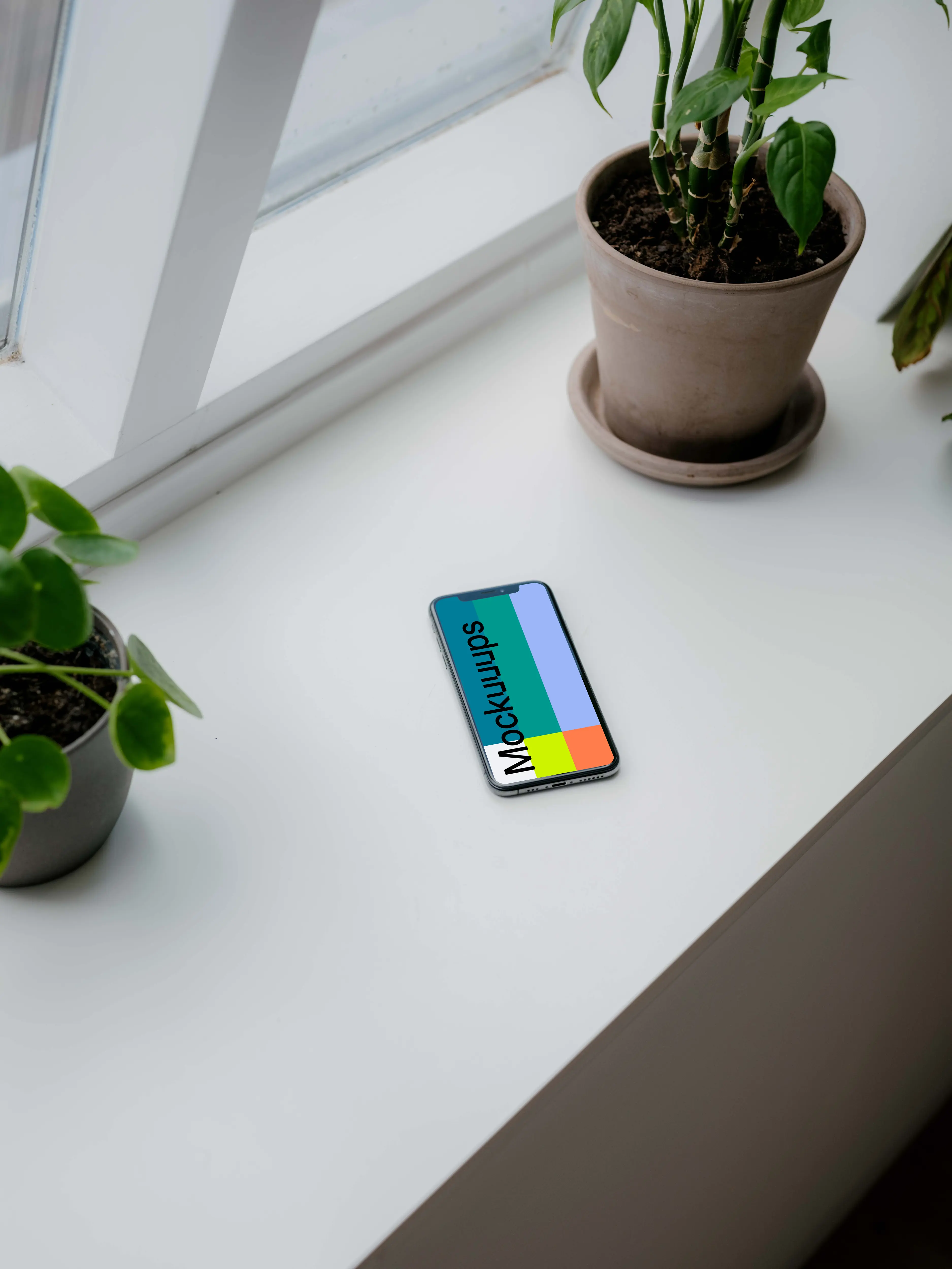 iPhone XS mockup on a window sill with plants