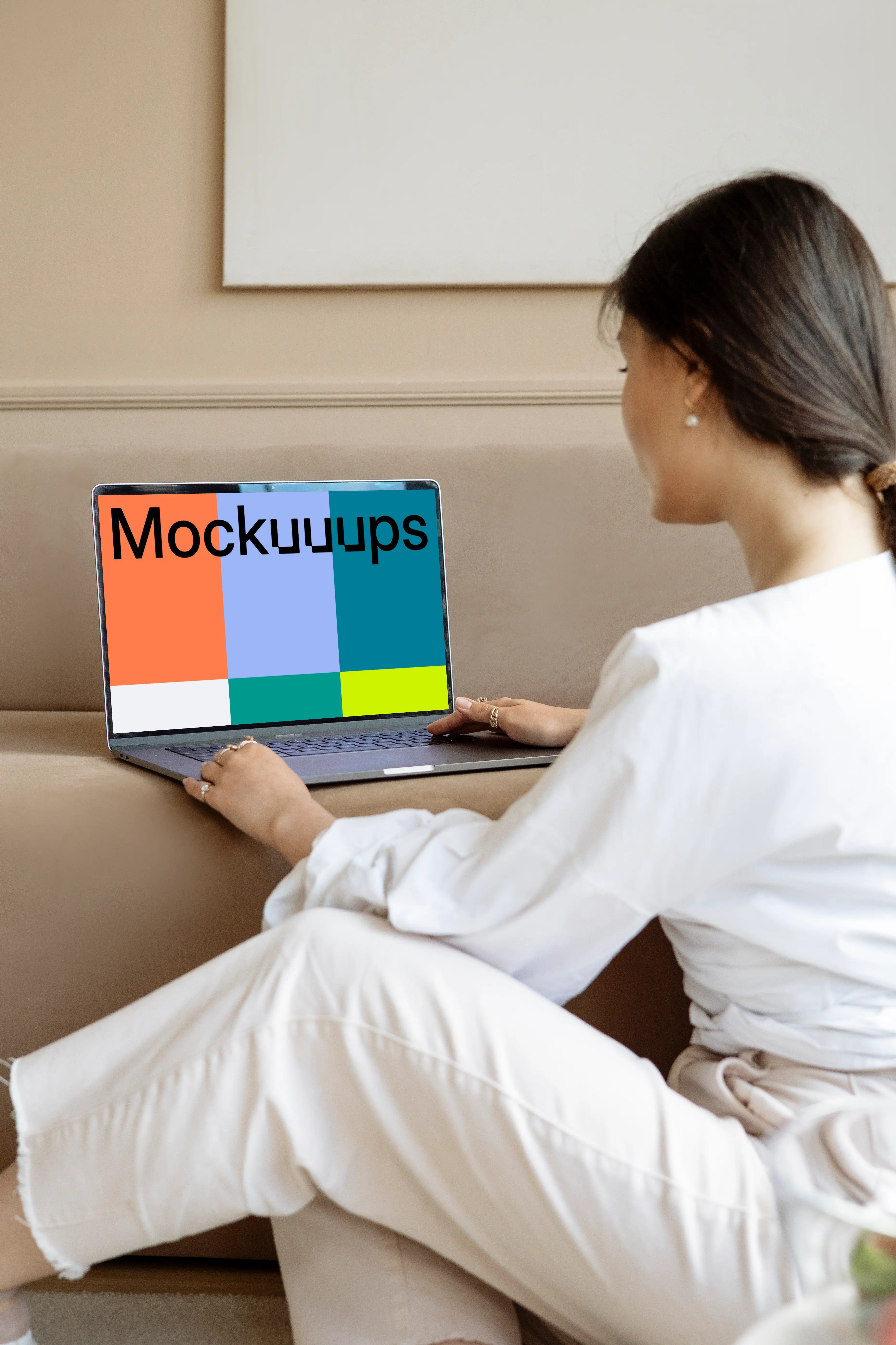 Lady using a MacBook Pro mockup on a sofa