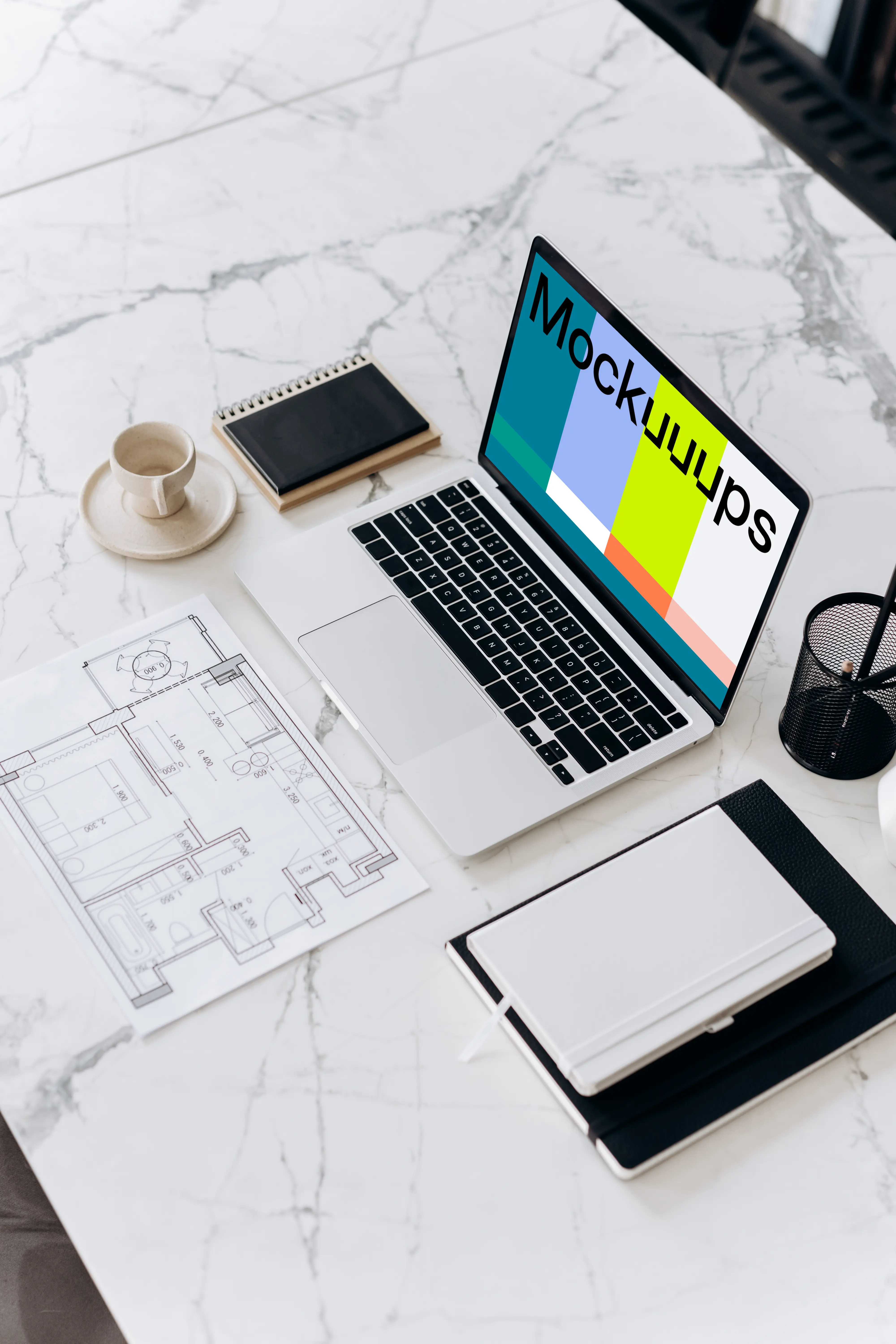 Laptop mockup on a table beside a house plan