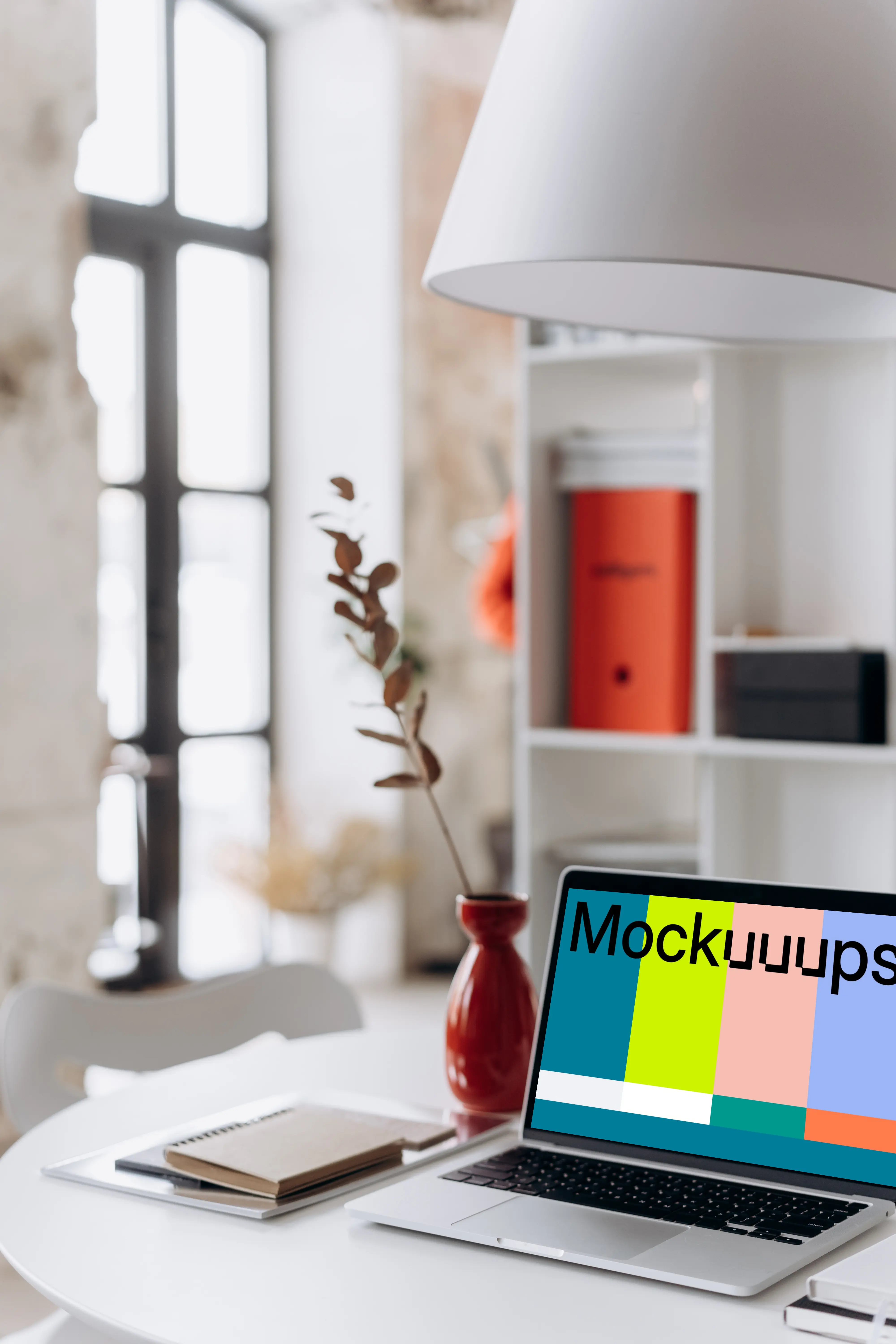 MacBook Pro mockup beside a tall red vase