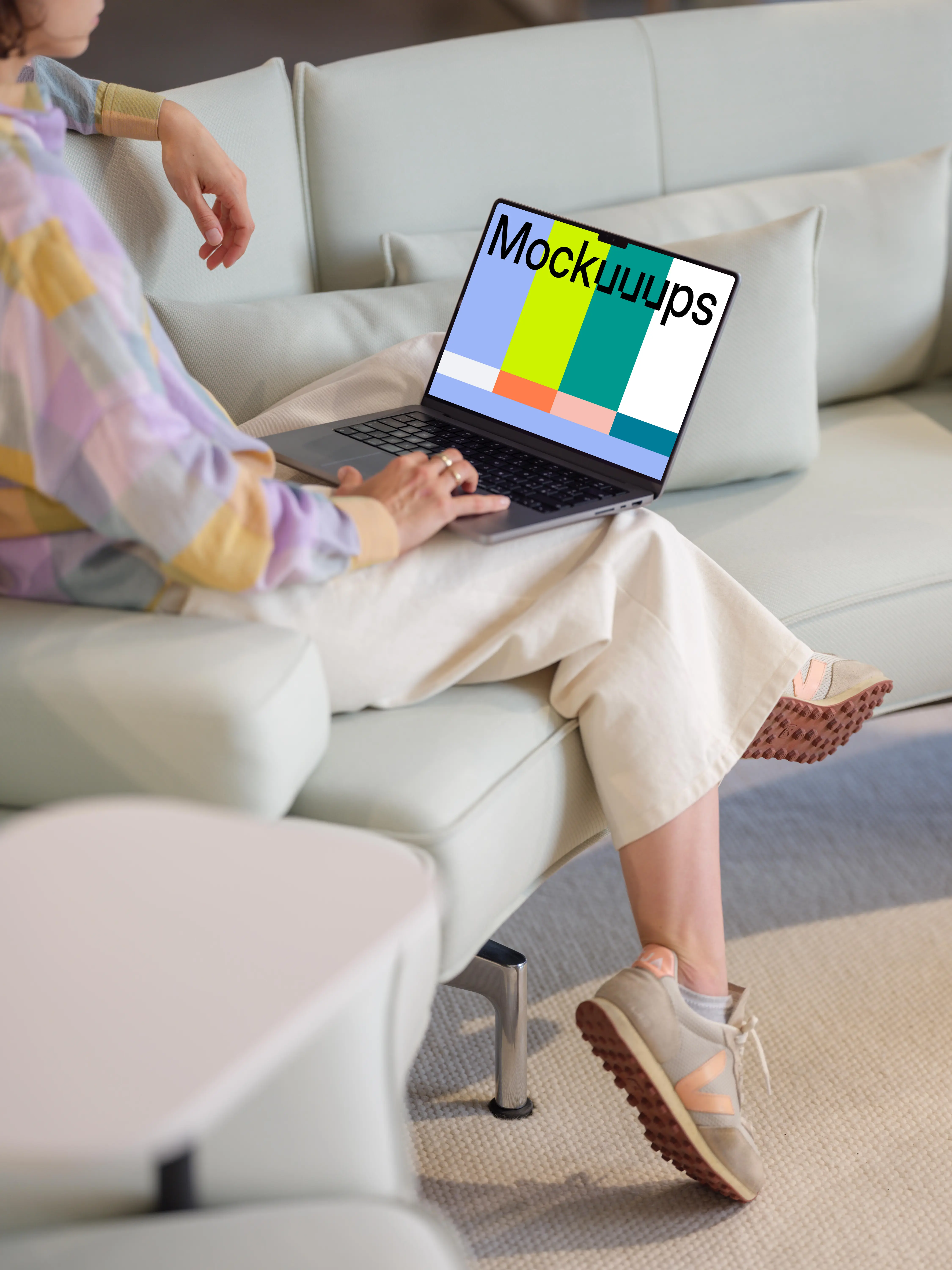 MacBook Pro mockup with woman on a modern sofa