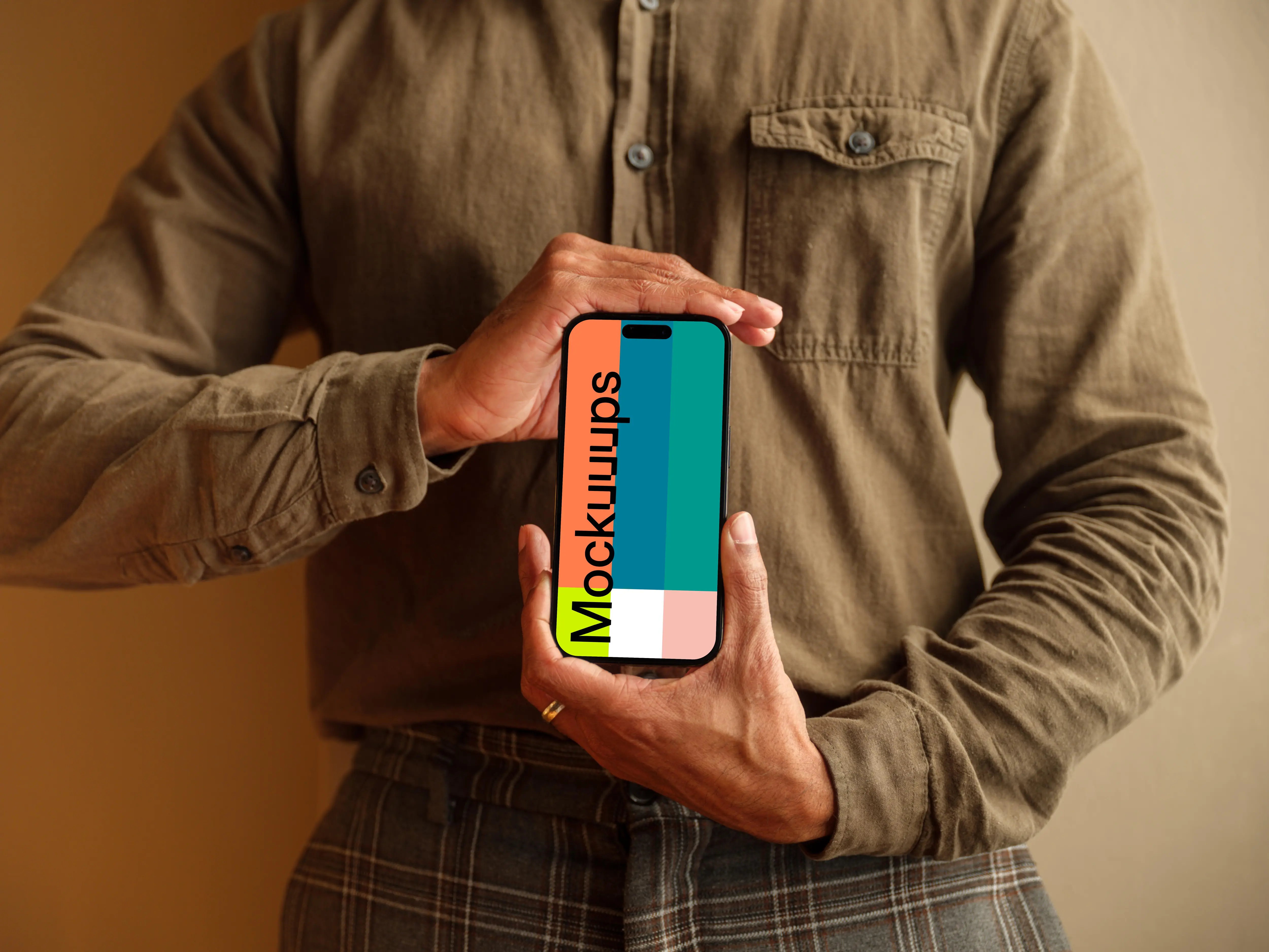 Free mockup of man in khaki shirt holding the iPhone