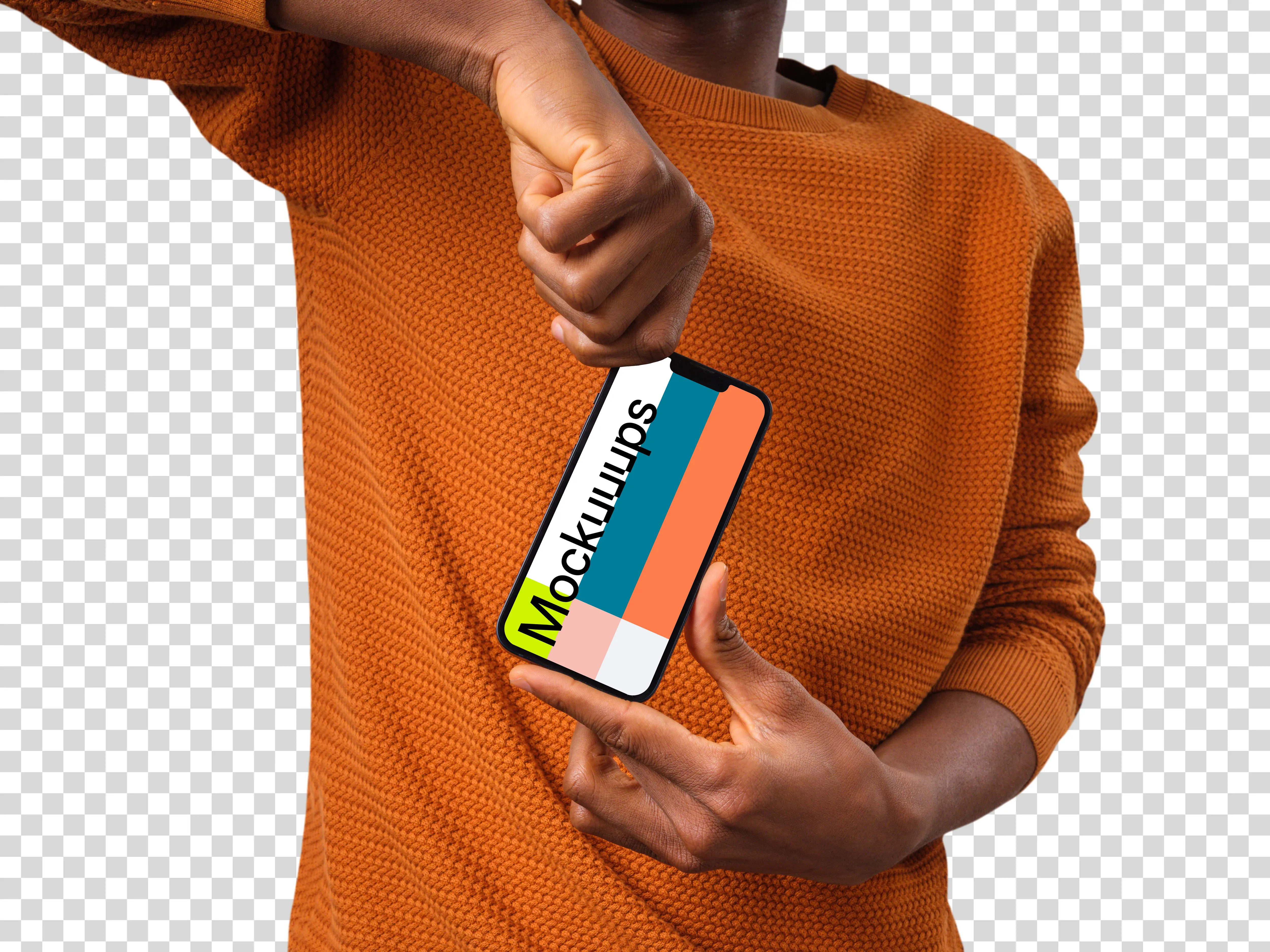 Man in orange sweater holding iPhone mockup from the top
