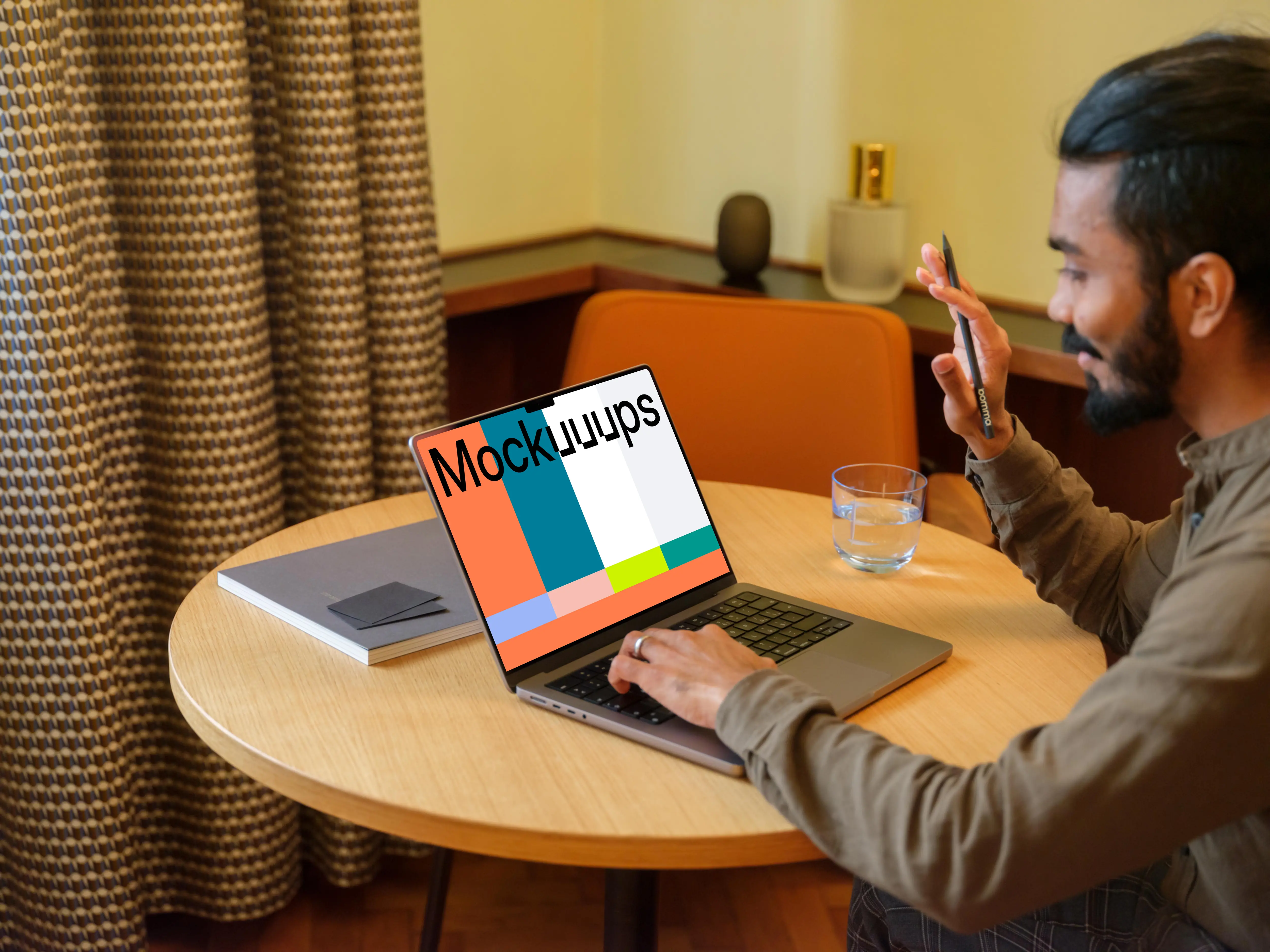 Man working on a MacBook Pro mockup in lounge 
