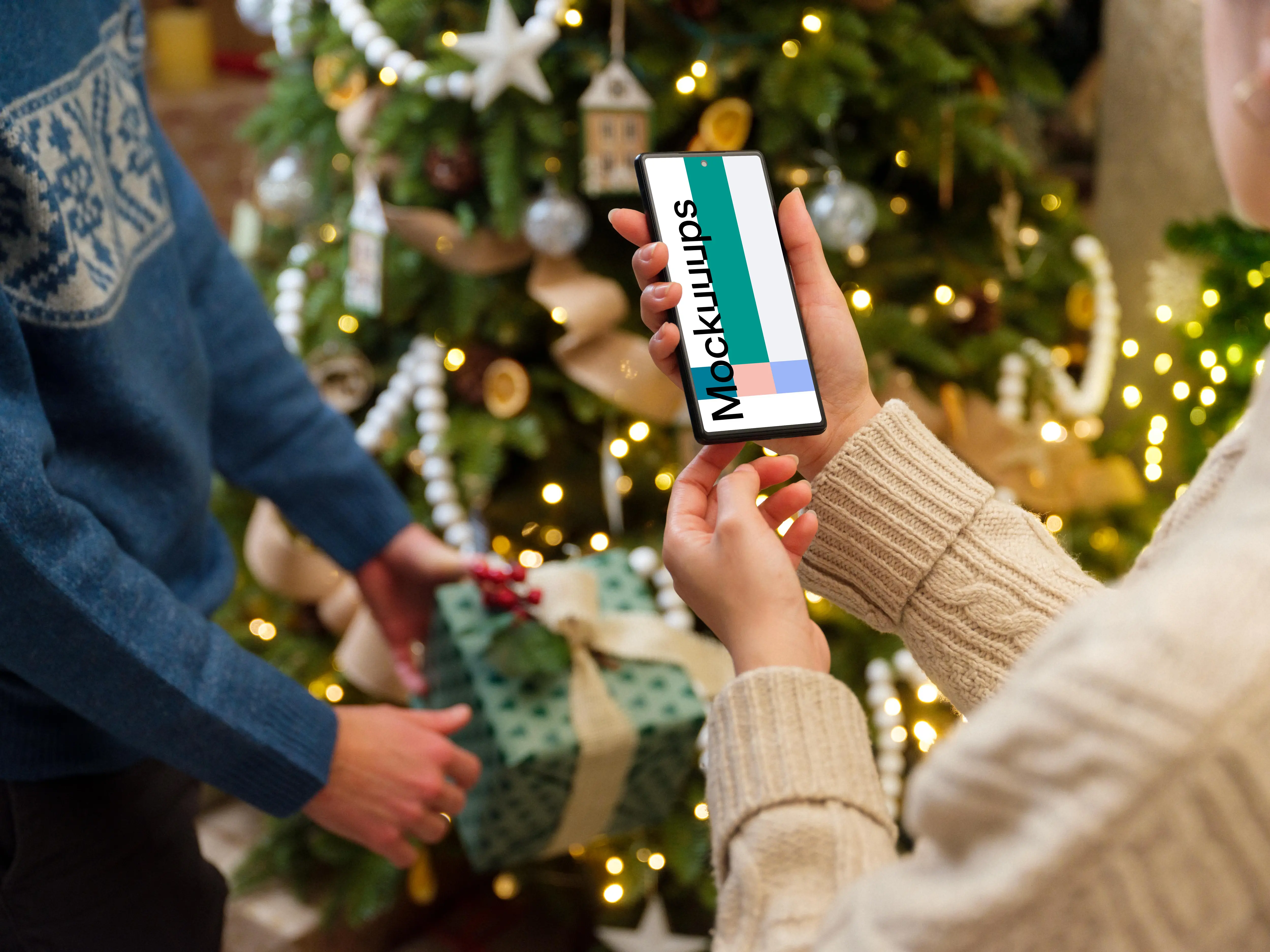 Phone mockup in hands next to the Christmas tree