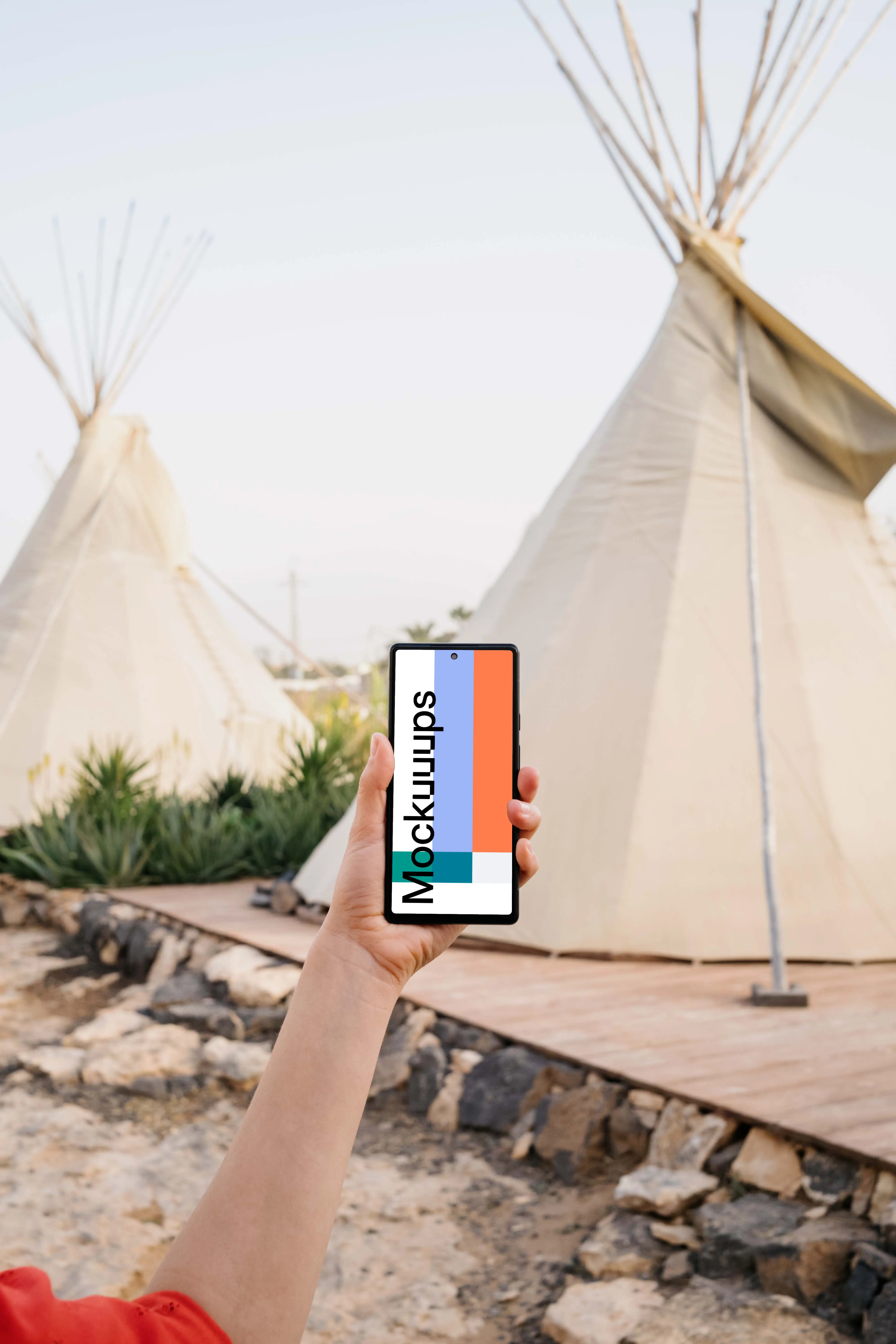 Pixel 6 mockup held by a user at an outdoor campsite
