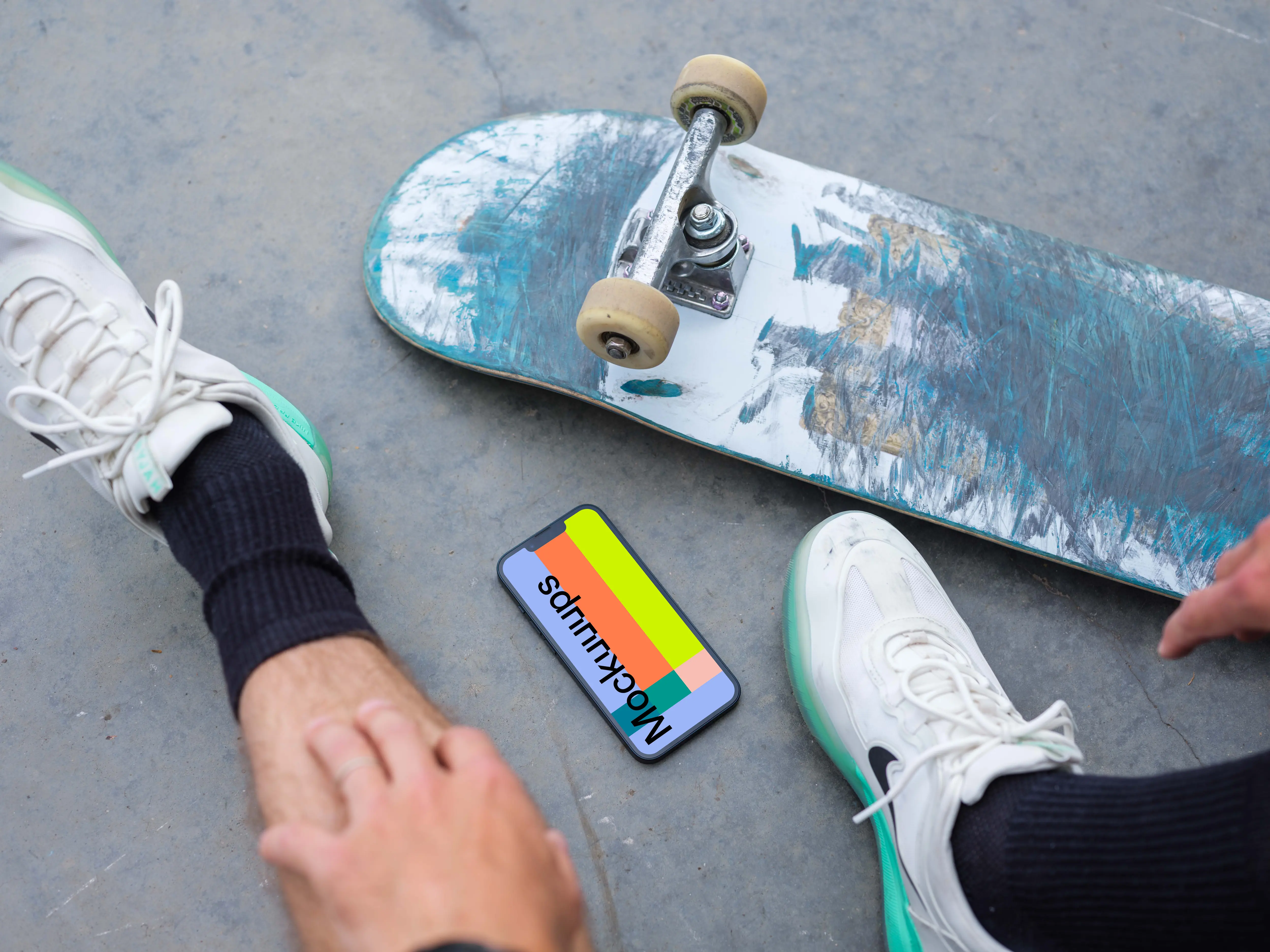 Skateboarder sitting next to an iPhone 13 mockup