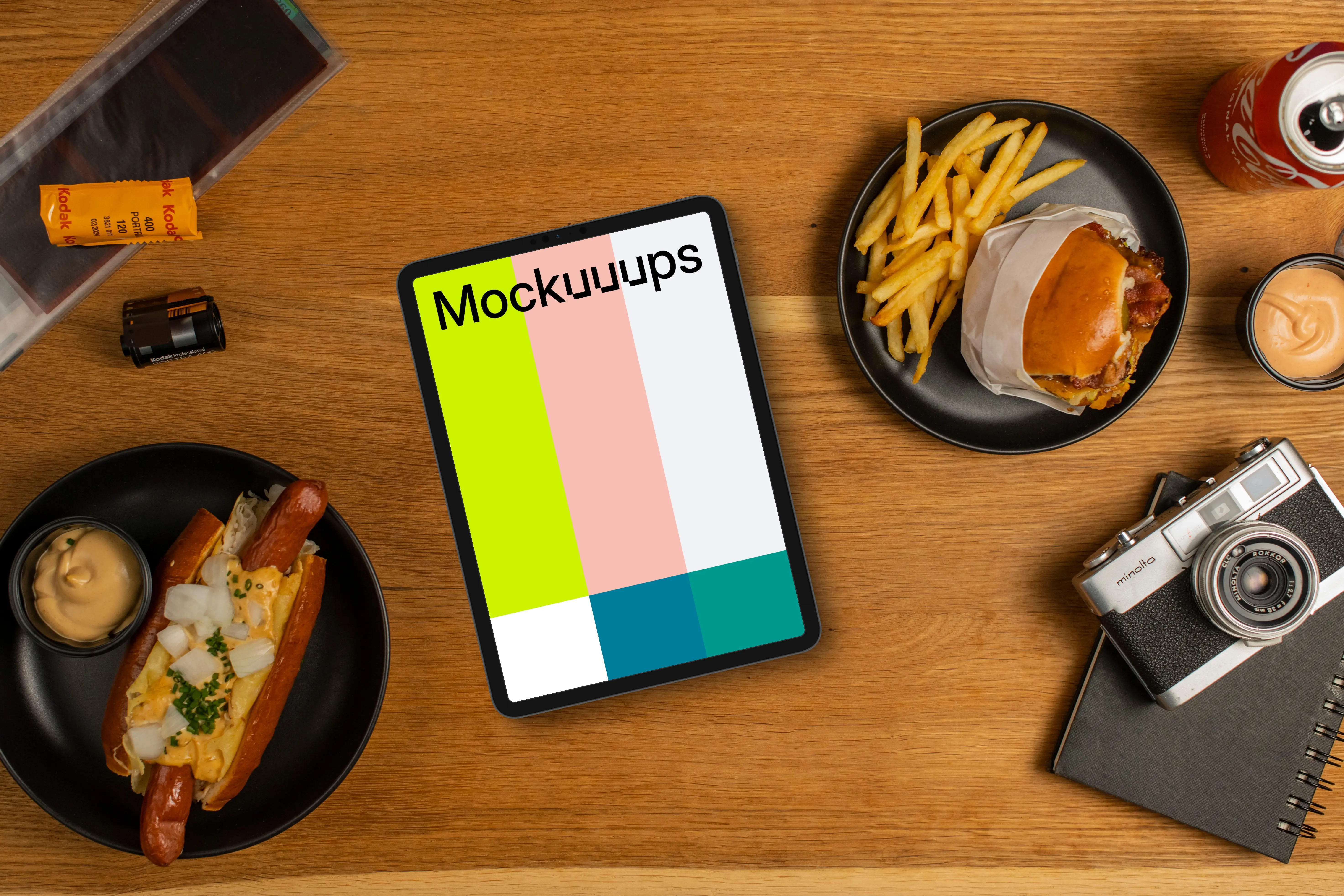 Tablet mockup between plates with hot-dogs