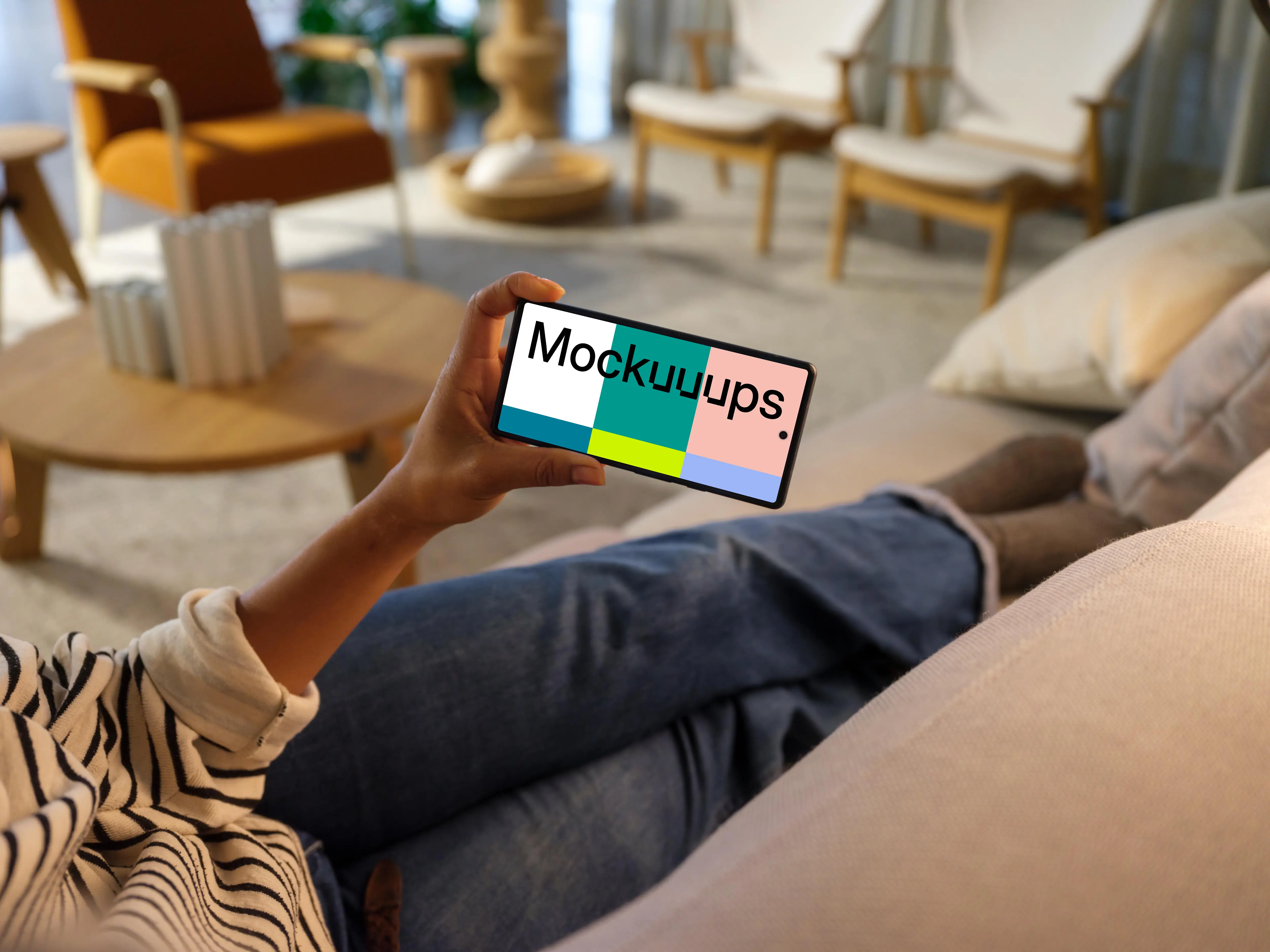 Woman hand holding a phone while laying on a couch
