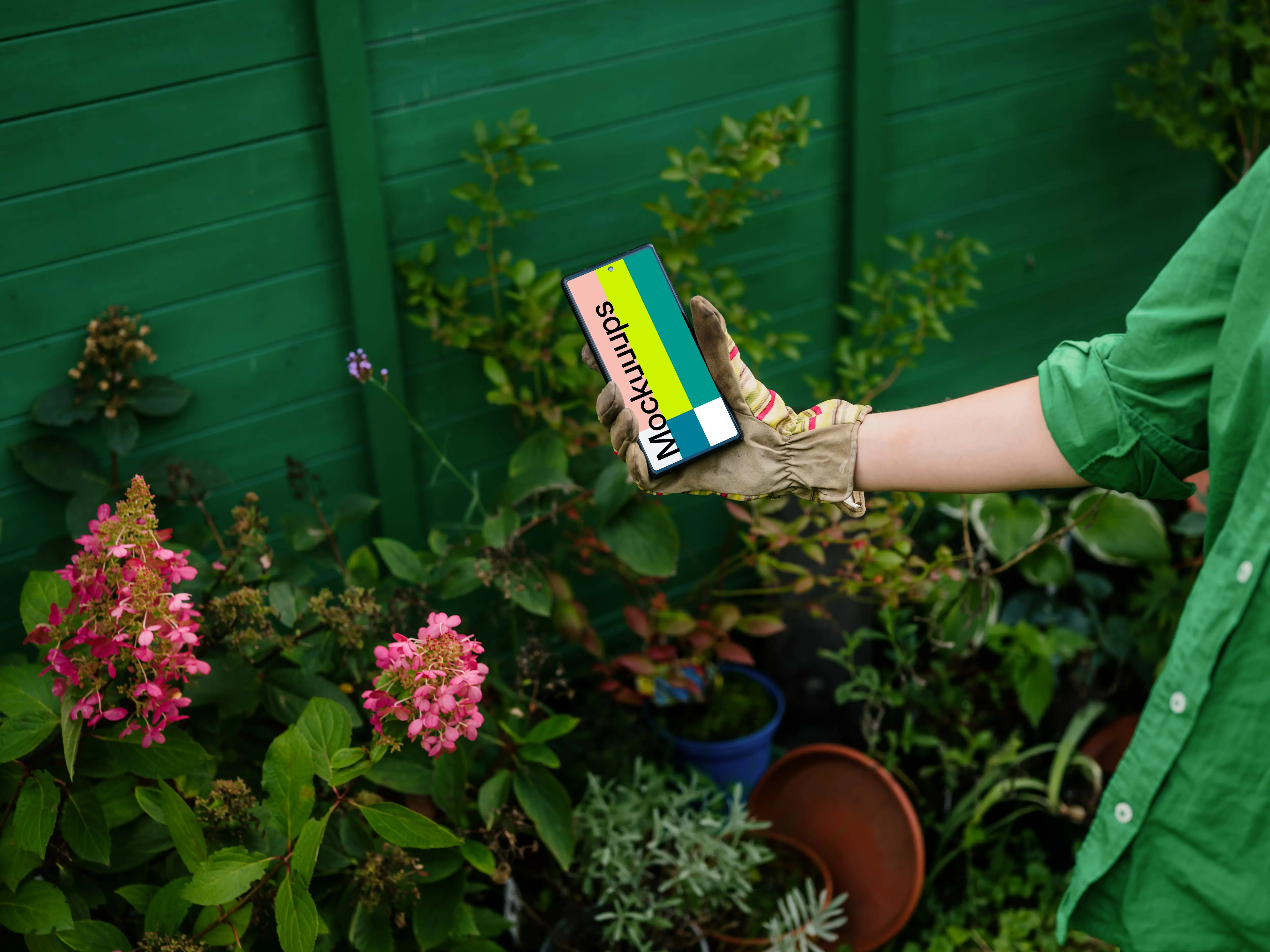 Woman holding a phone in garden gloves mockup