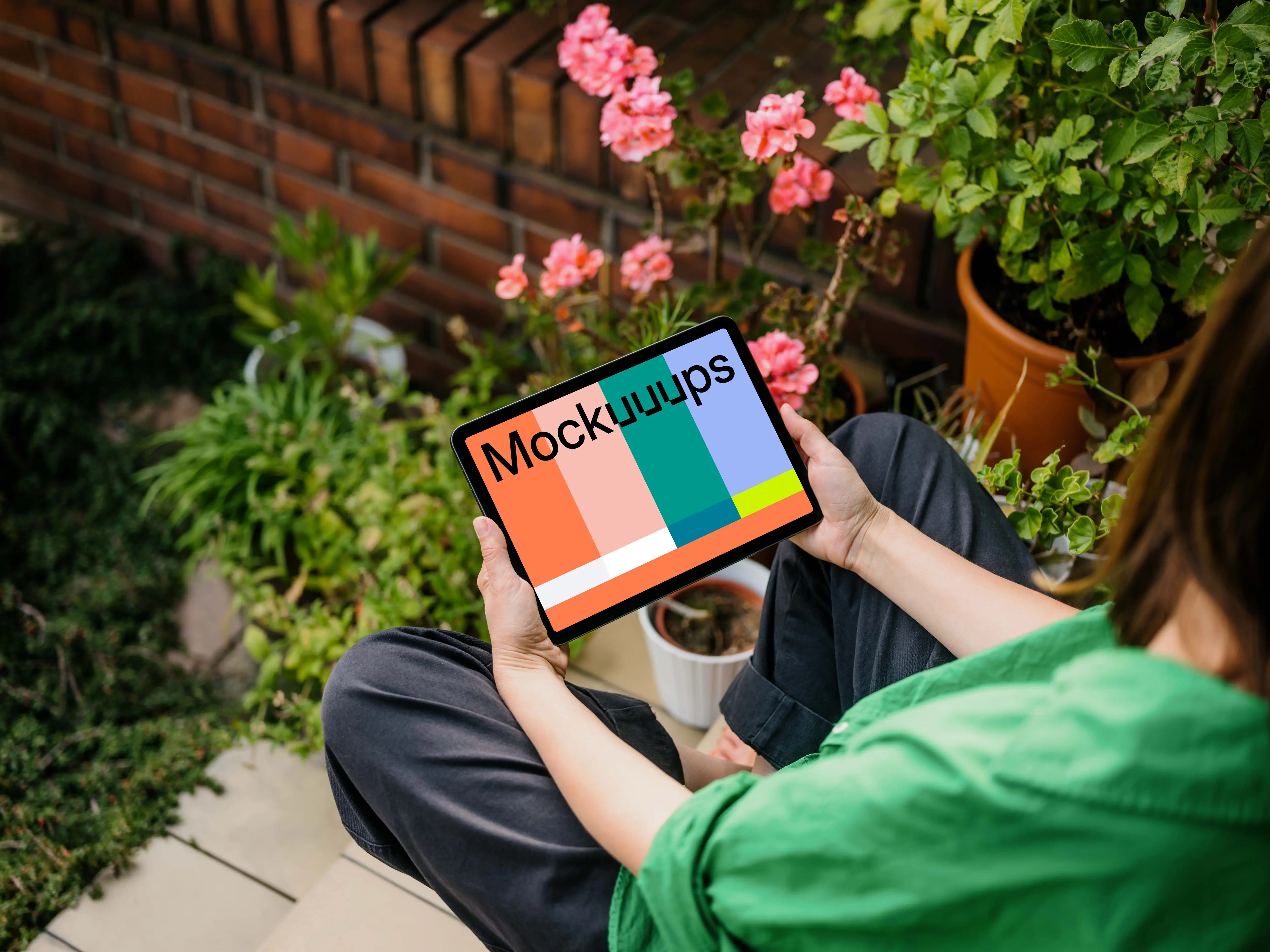 Woman holding an iPad Air in garden full of plants