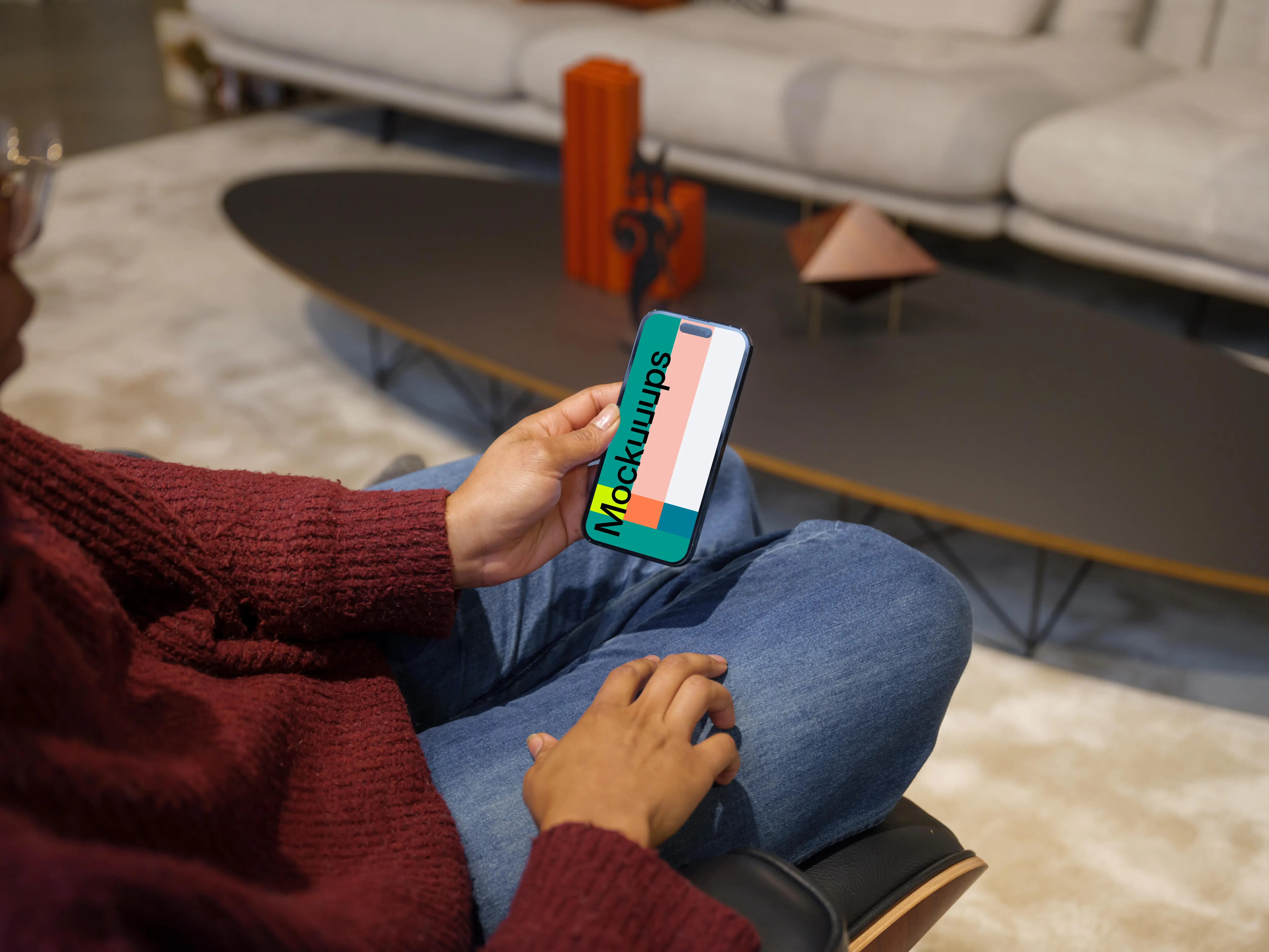 Woman in burgundy sweater holding an iPhone 14 Pro