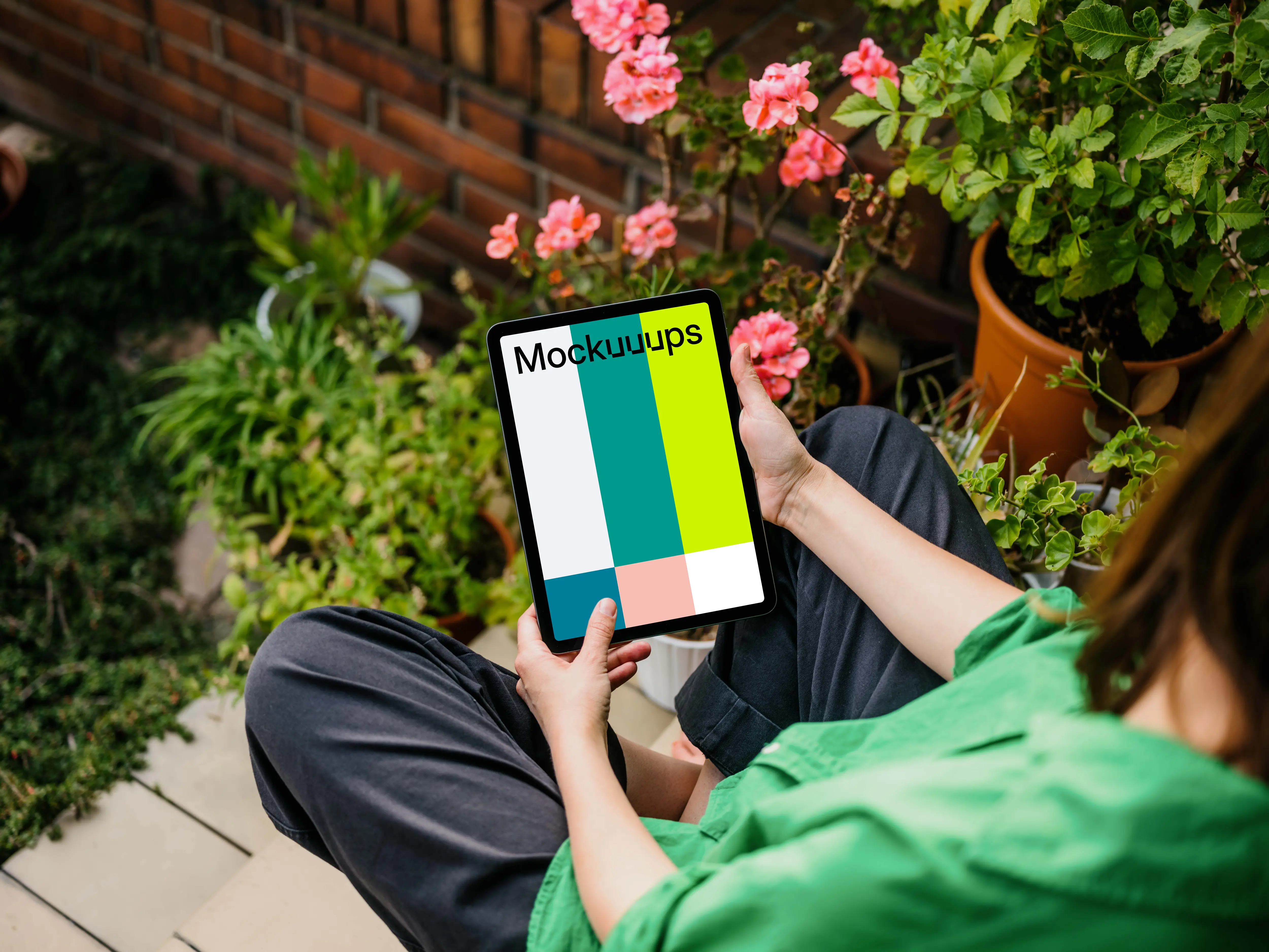 Woman sitting in garden while holding an iPad Air mockup