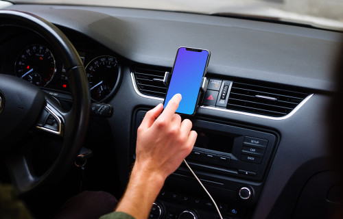 Driver interacting with iPhone 11 mockup in car mount