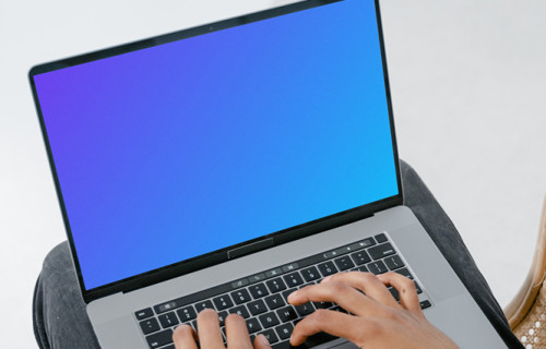 Grey MacBook mockup on a user’s lap