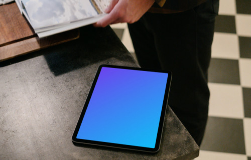 iPad Air mockup on a black table next to a user