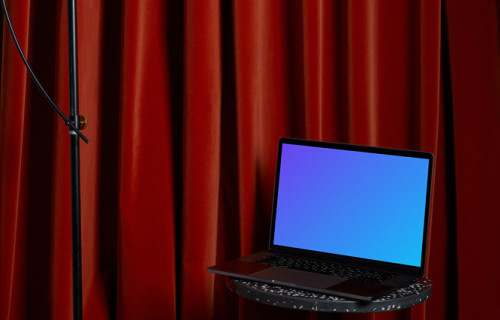 MacBook mockup on a black stool with a tall lamp hanging above it