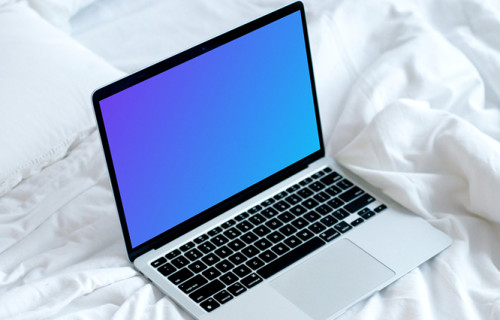MacBook mockup on a white bed with coffee on a saucer