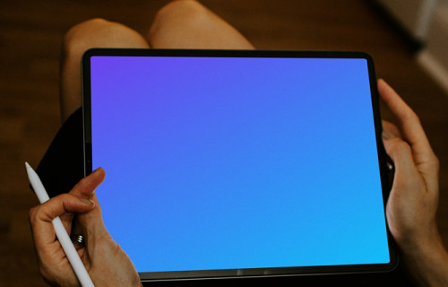 Tablet mockup held by lady with Apple pencil