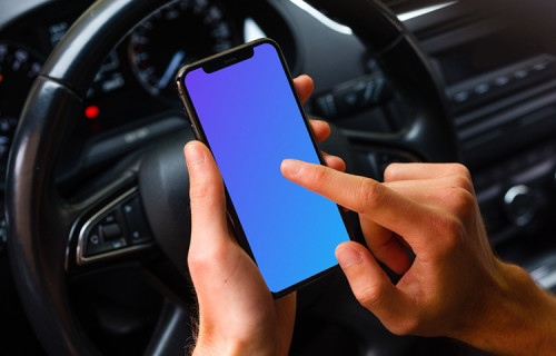 Driver tapping iPhone 11 mockup in front of steering wheel