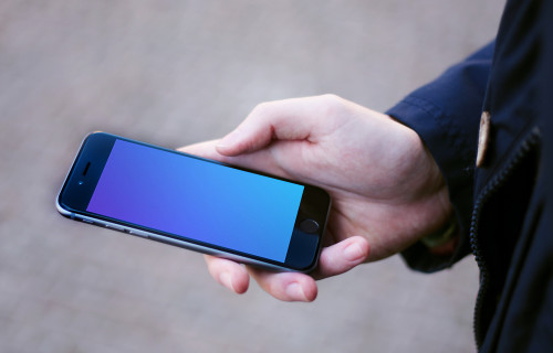 Holding iPhone 6 mockup on the street