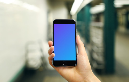 Holding iPhone 6s mockup on a Train Station