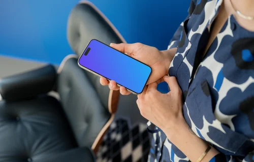 iPhone 15 Pro mockup in woman's hand against blue background