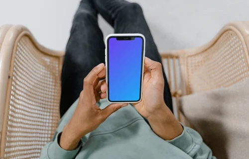 iPhone mockup segurado pelo usuário em uma cadeira 