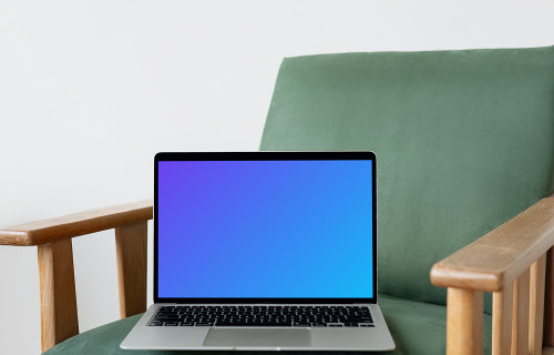 MacBook mockup on a green chair with wooden armrest