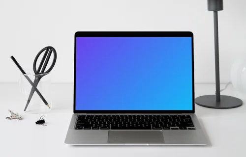 MacBook mockup on a white table with black table lamp at the side