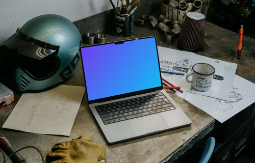 MacBook Pro mockup beside a motorcylce helmet