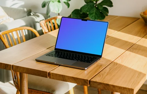 MacBook Pro grátis mockup em uma mesa com uma planta ao fundo