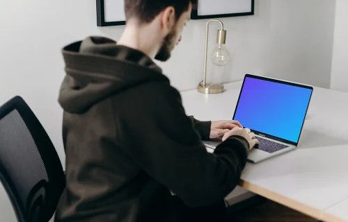 MacBook Pro mockup em uma mesa branca perto de uma lâmpada