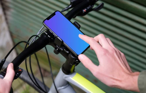 Homme à vélo près d'un garage avec iPhone 11 Pro mockup dans le support de vélo