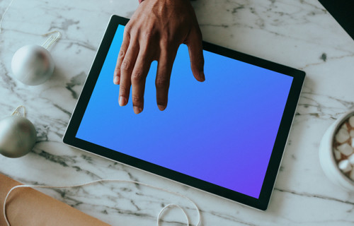 Microsoft Surface mockup held by a user on a marble table