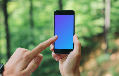 Pointing on iPhone 6 mockup in the forest