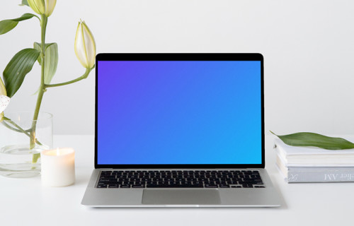 Simple MacBook mockup on a white workstation table with a plant at the side