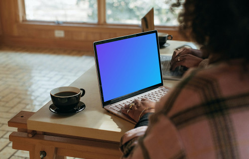 Sitting next to the colleague and working on the Microsoft Surface Laptop mockup