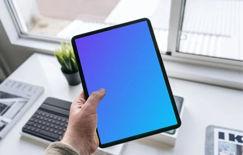 Tablet mockup held by man over work desk 