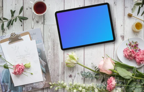 Tablet mockup on white wood decorated by flowers