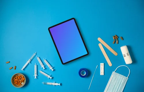 Tablet surrounded by medical essentials